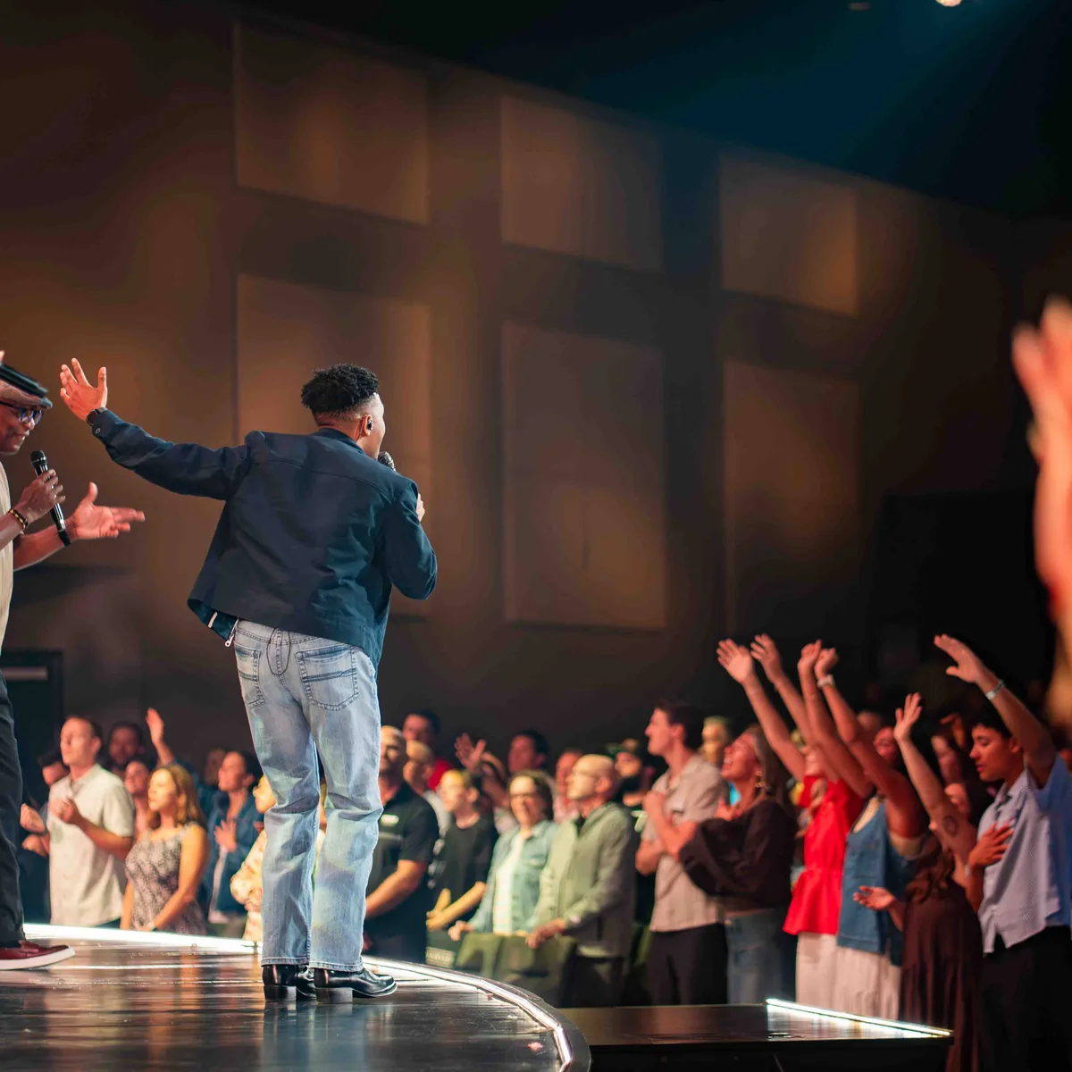 The worship team leading from the stage at Keystone as the congregation sings with hands raised